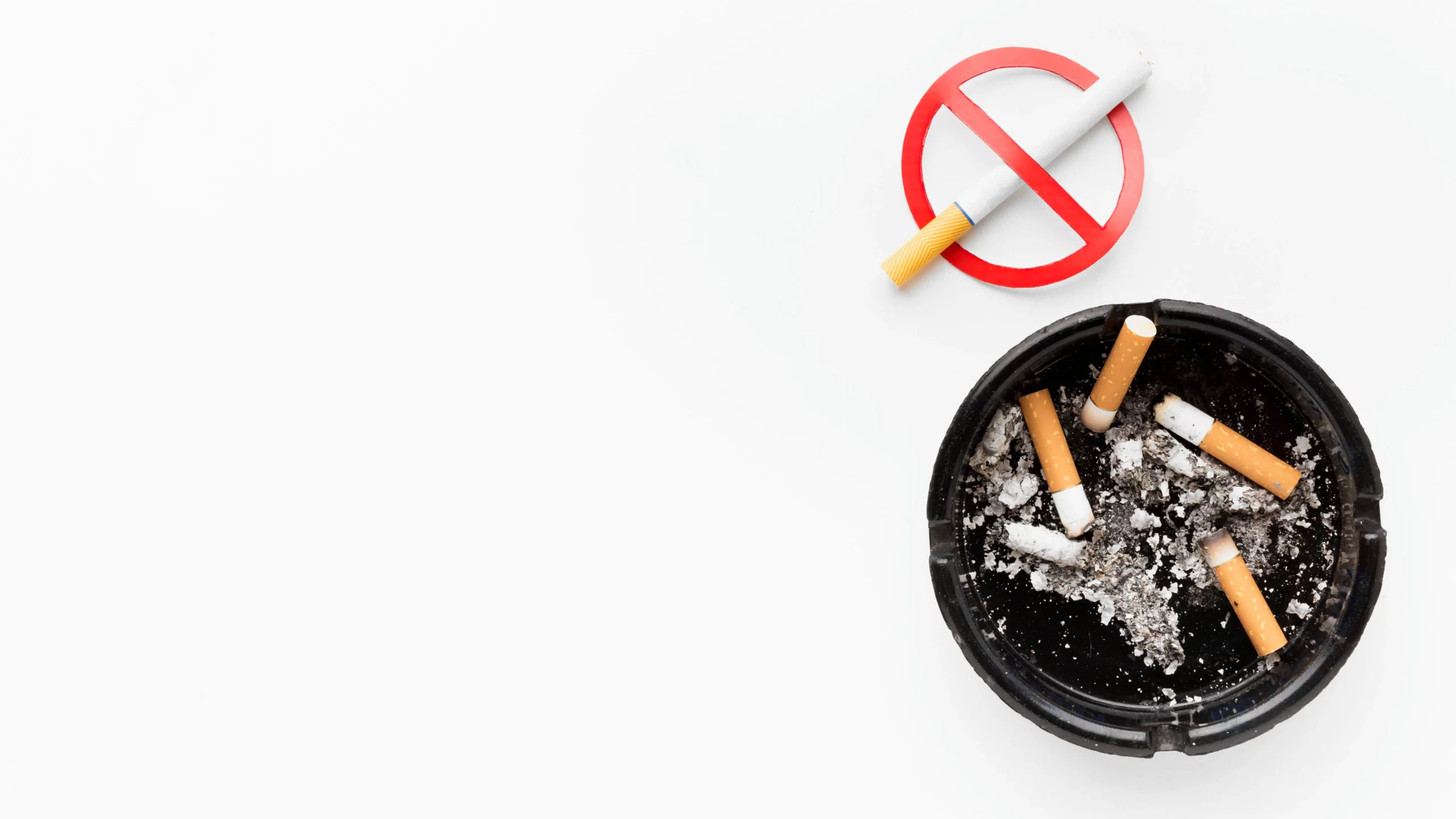 Ashtray with cigarette butts, no smoking sign nearby.