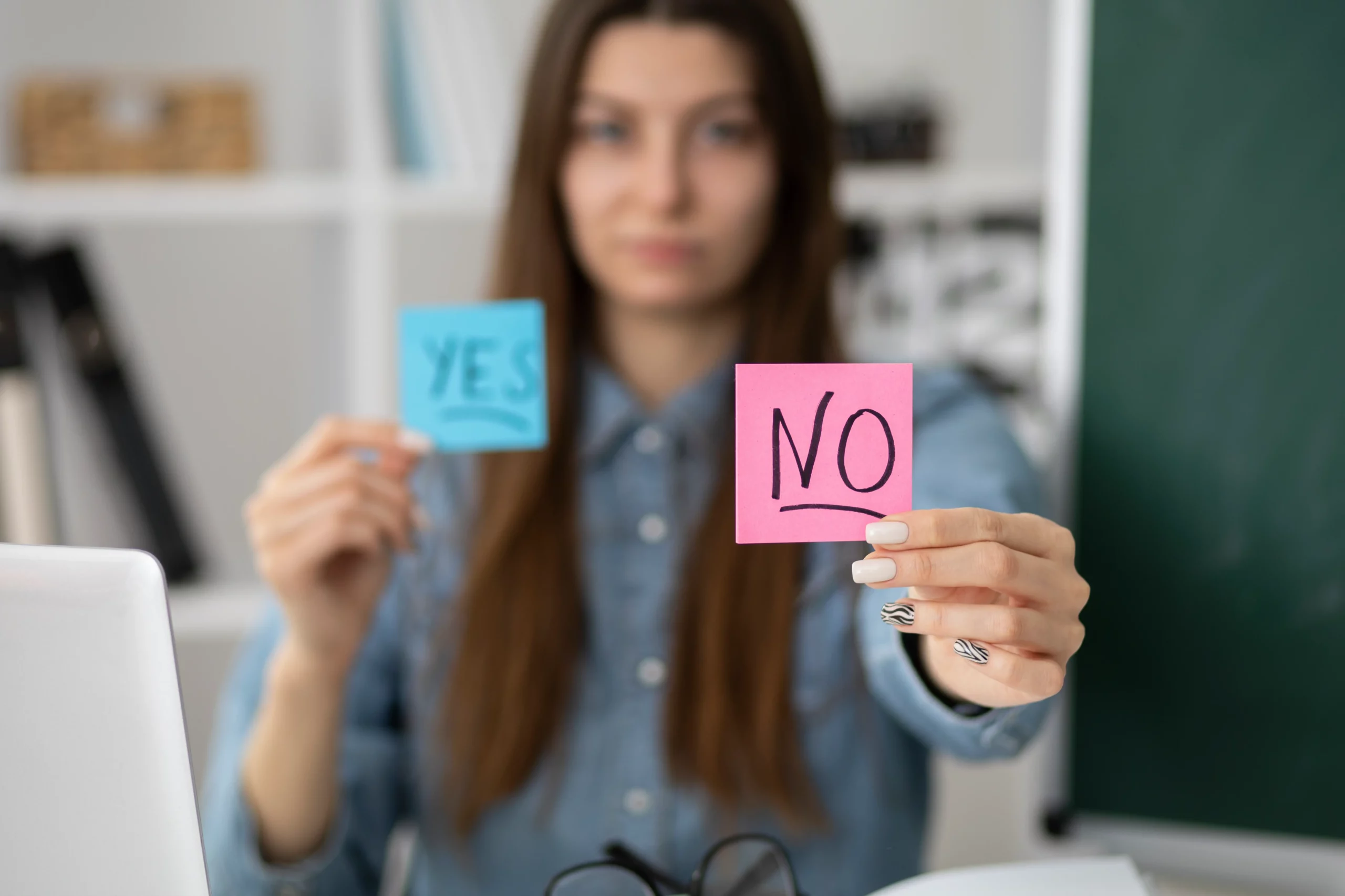 Woman holding "Yes" and "No" sticky notes in each hand.