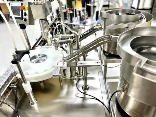 Automated machinery in a factory setting with metal components and control panel.